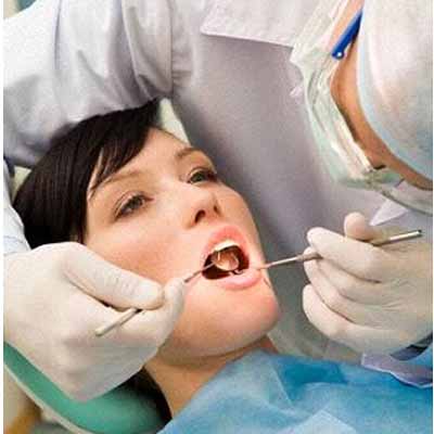 девушка у стоматолога во время имплантации-протезировании зубов