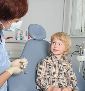 ребенок в кресле у стоматолога при установке брекетов