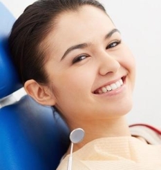 улыюбающаяся девушка в кресле стоматолога